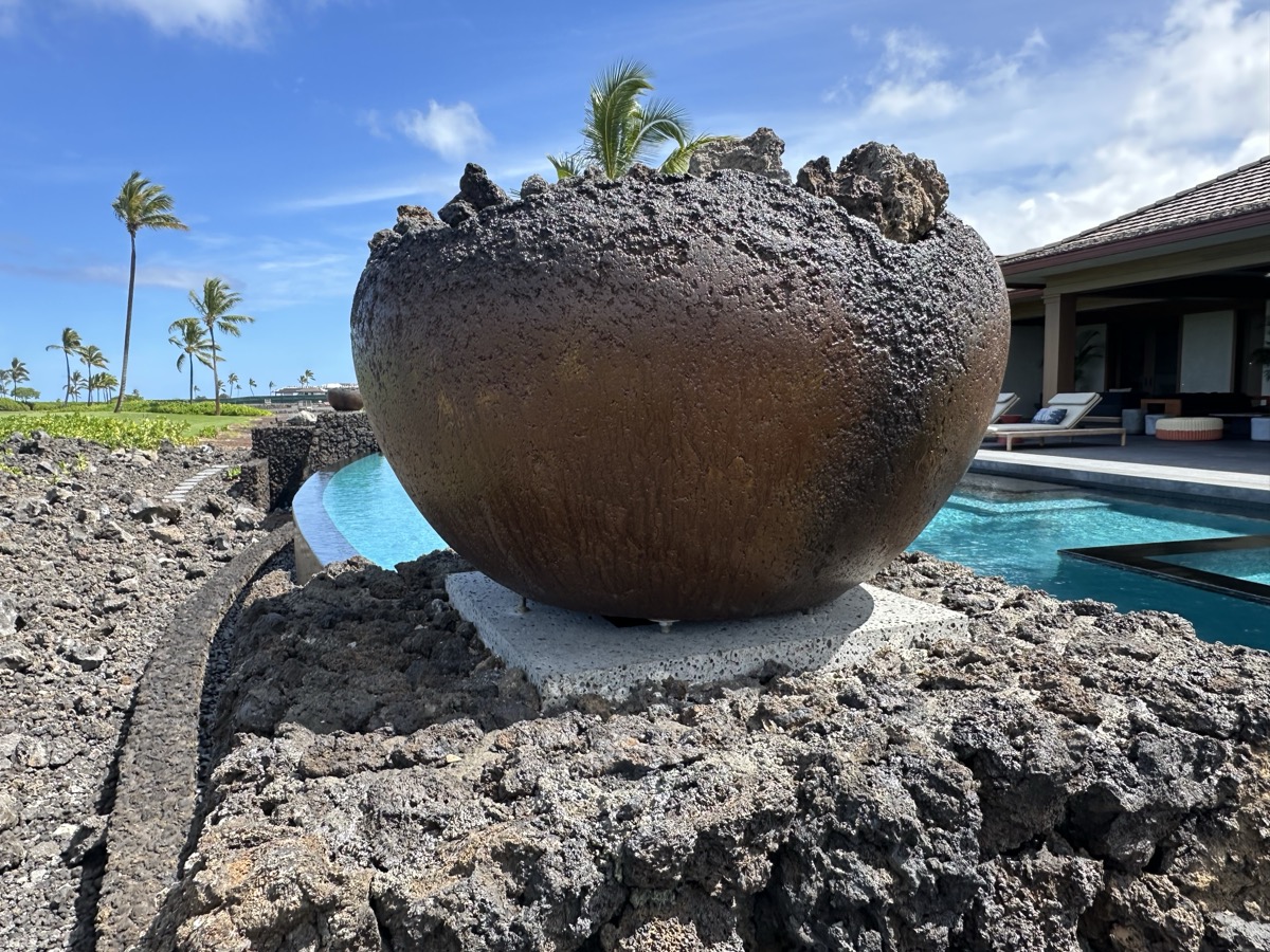 KAZ fire bowl set into volcanic lava rock on a luxury pool deck