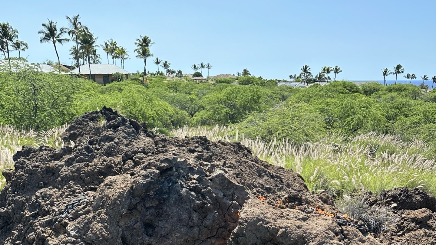 Lava mound with fire seeping through cracks, palm trees and ocean in background — Kona, Hawaii