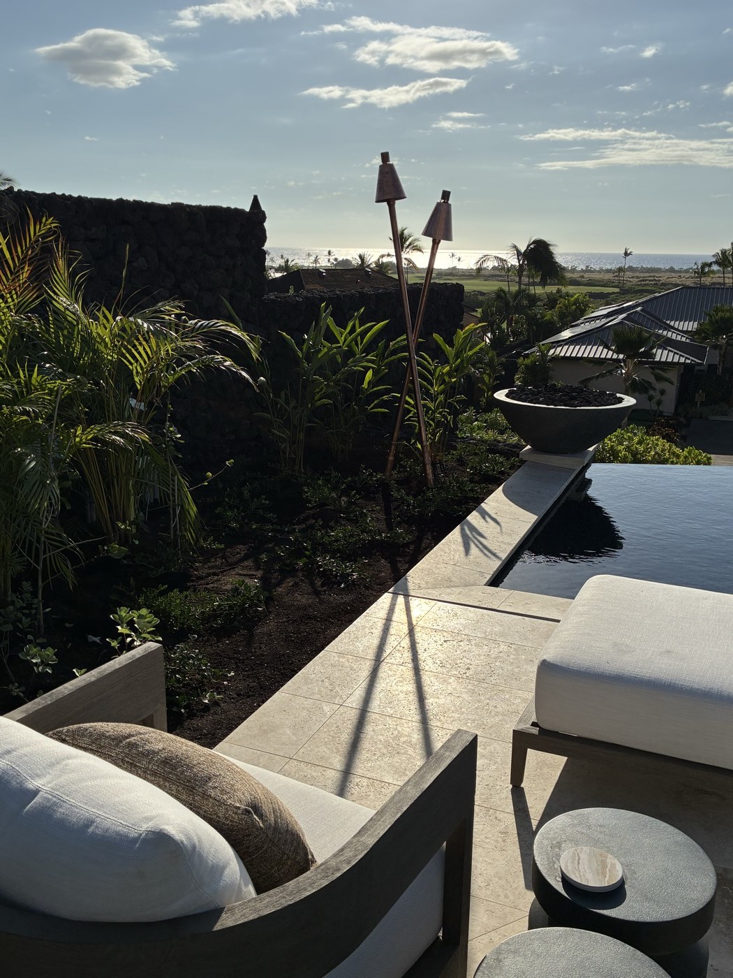 KAZ crossed copper tikis on a luxury Kona estate terrace with ocean view